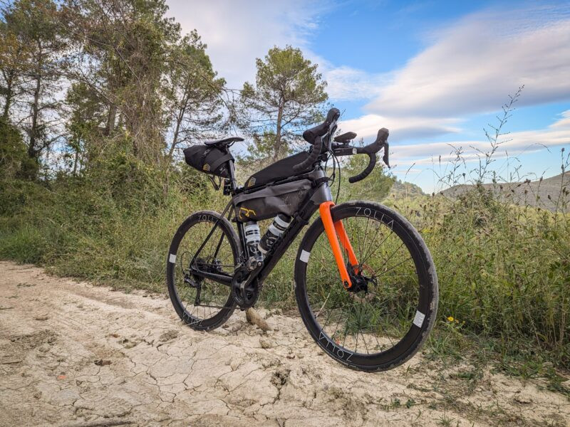 zolla-gravel-orange-fork-2024 Gravel bike with an orange fork and Zolla wheels on a sandy track